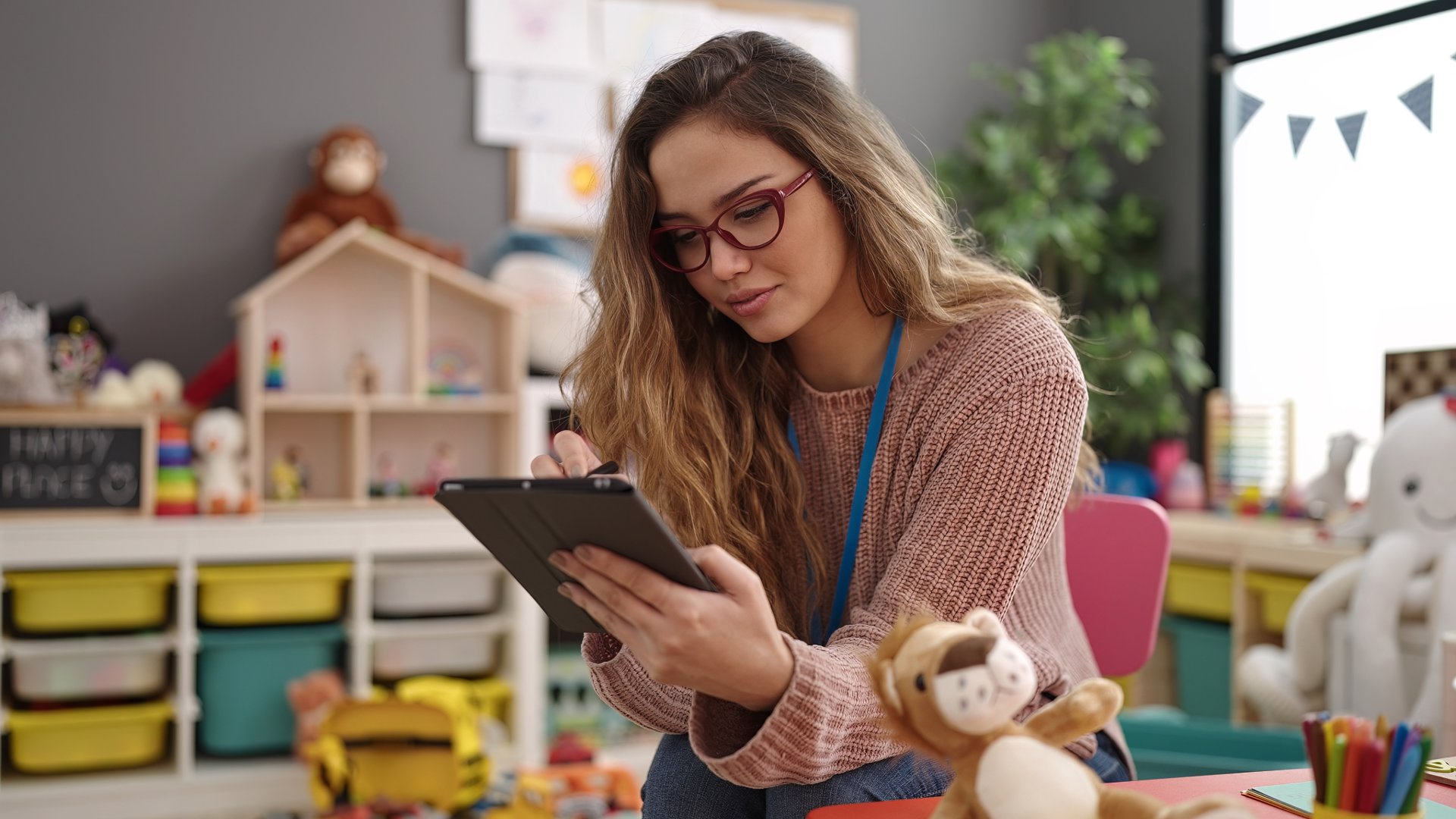 A teacher using a custom classroom management app on a tablet to streamline lesson planning and student work.